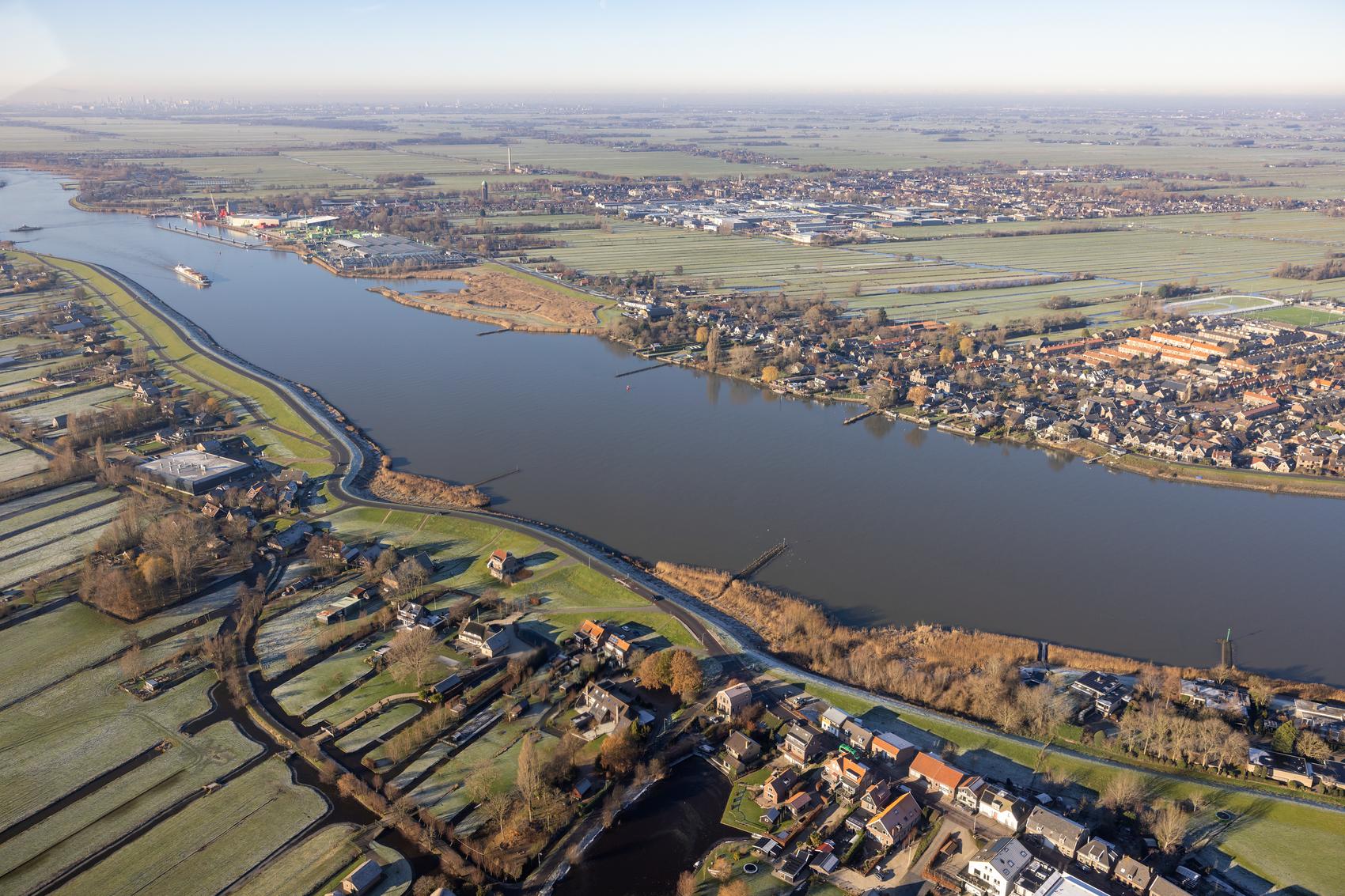 Luchtfoto van de Krimpenerwaard met rivieren, polders, dorpen en landelijke bebouwing.